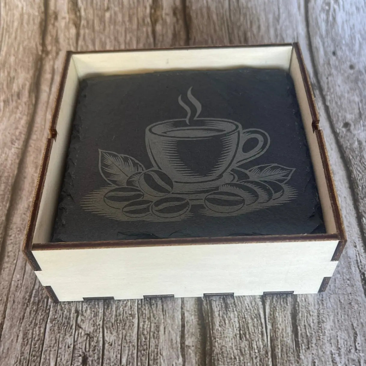 Détail gravure laser tasse de café et grains sur sous-verre en ardoise naturelle