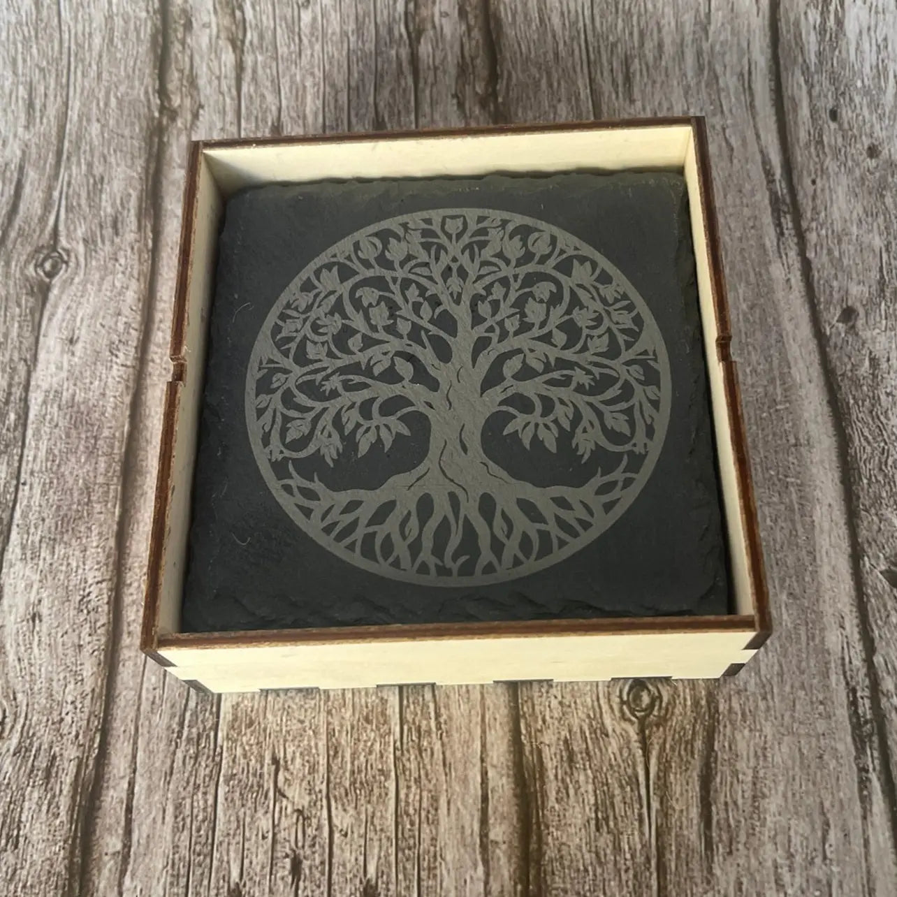 Coffret de rangement en bois clair contenant les dessous de verre en ardoise