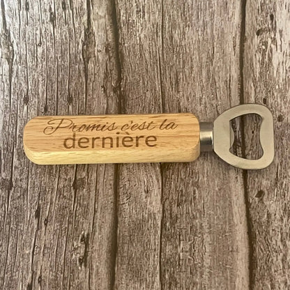 Vue de dessus du décapsuleur en bois clair gravé avec la phrase drôle sur le dernier verre.