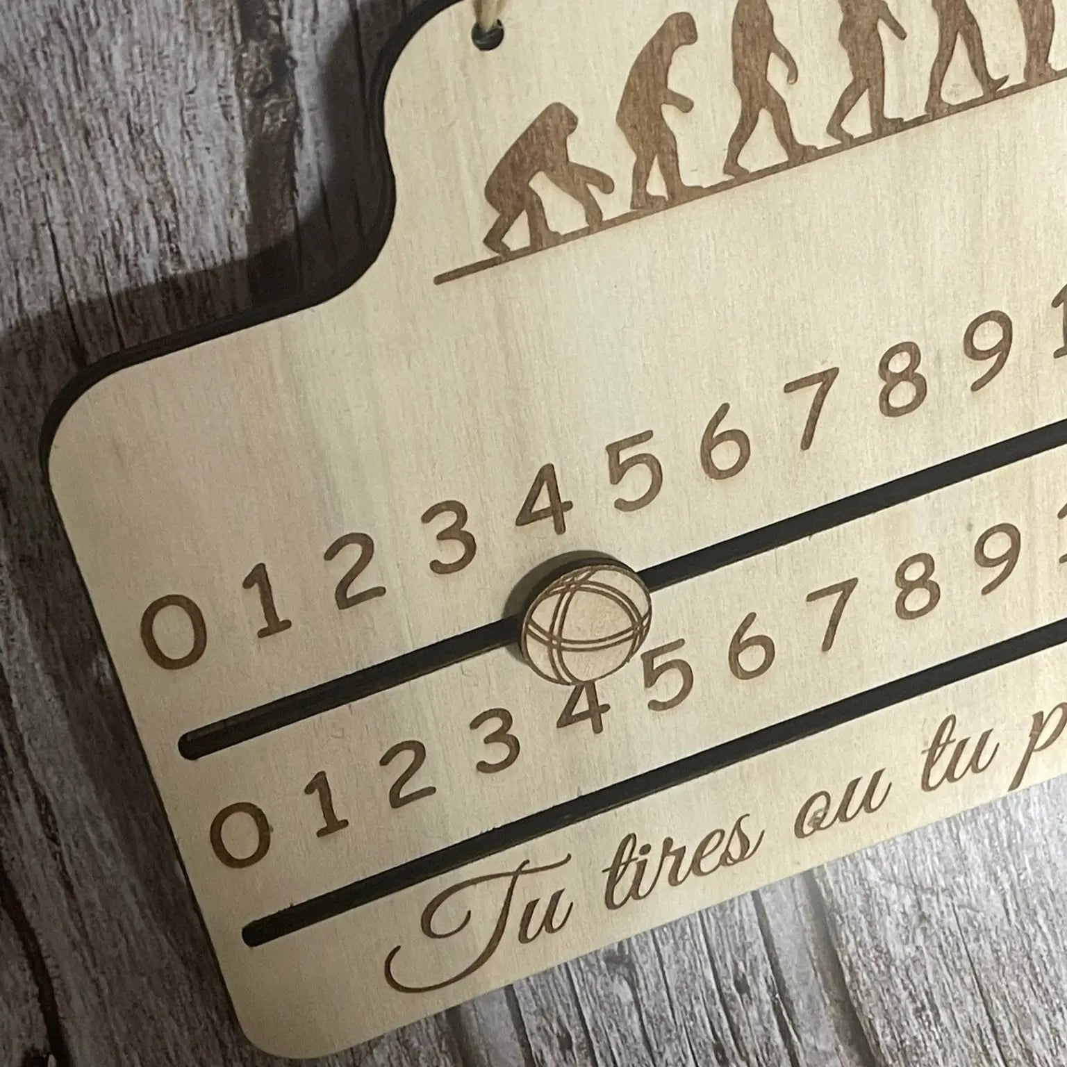 Gros plan sur les deux réglettes coulissantes du compteur de score pétanque avec chiffres gravés lisibles