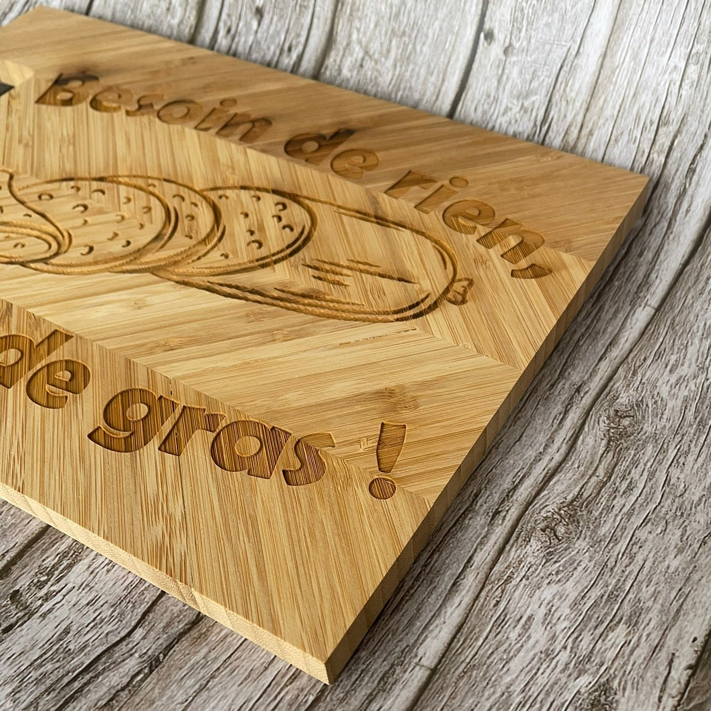 Gravure laser du message humoristique “Besoin de rien, envie de gras !” sur planche en bambou - Atelier Tautavel