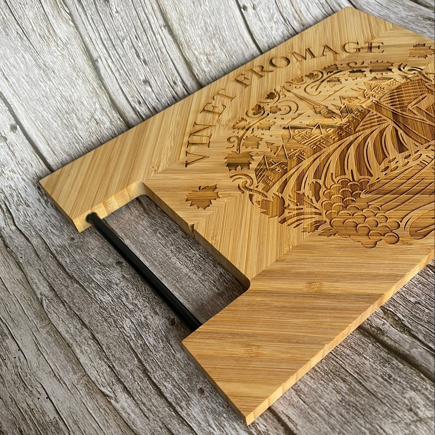 Détail de la poignée en métal et de l’épaisseur d’une planche à découper en bambou gravée