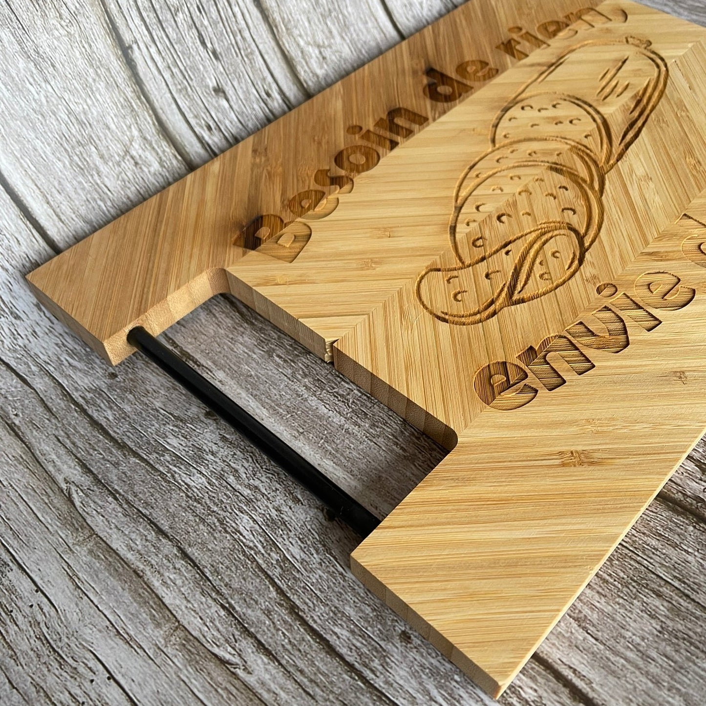 Détail de la poignée en métal et de l’épaisseur d’une planche à découper humour en bambou