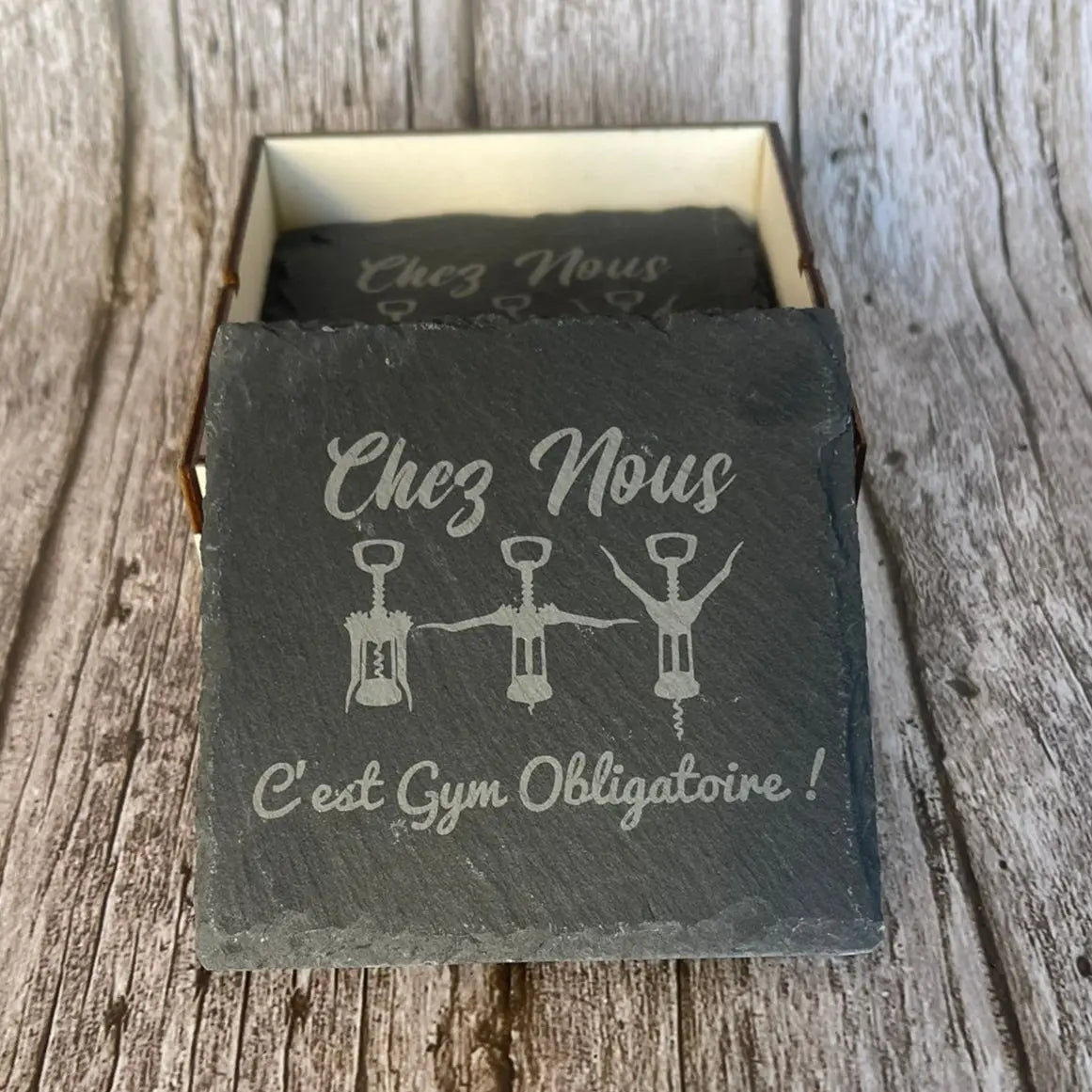 Présentation du dessous de verre Gym Obligatoire avec sa boîte de rangement