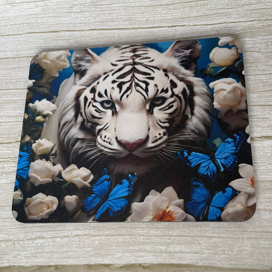 Vue de dessus du tapis de souris rectangulaire avec motif tête de tigre blanc entouré de roses et papillons.