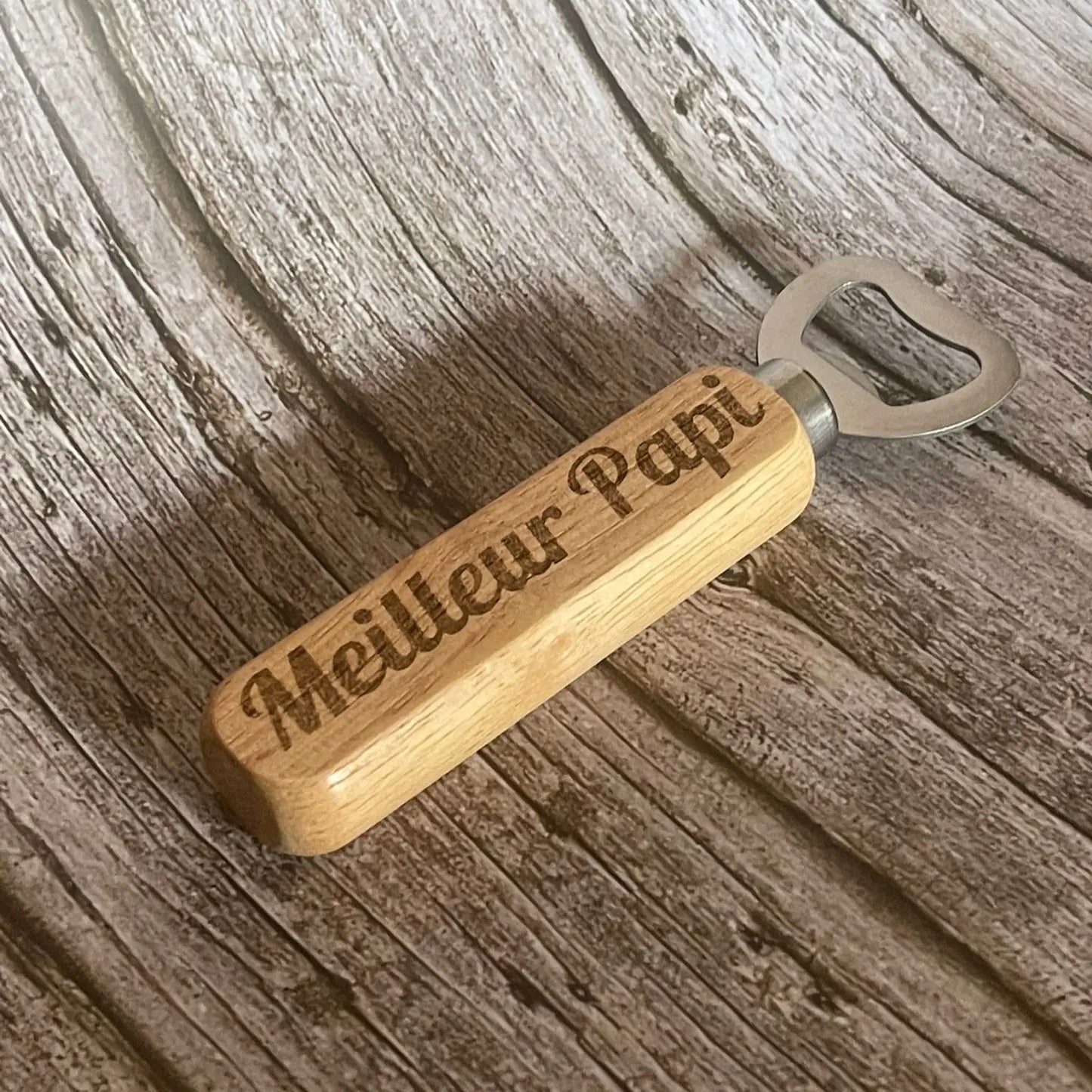 Gros plan sur la qualité de la gravure profonde "Meilleur Papi" sur le manche en bois.