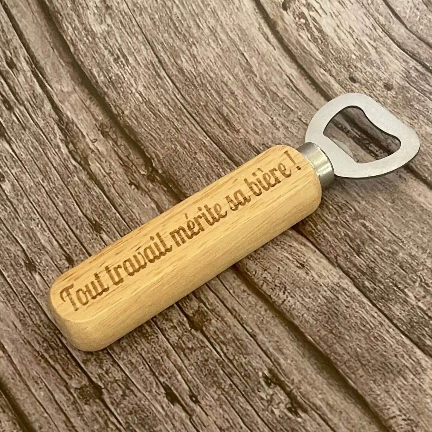 Gros plan sur la qualité de la gravure profonde de la citation sur le manche en bois.