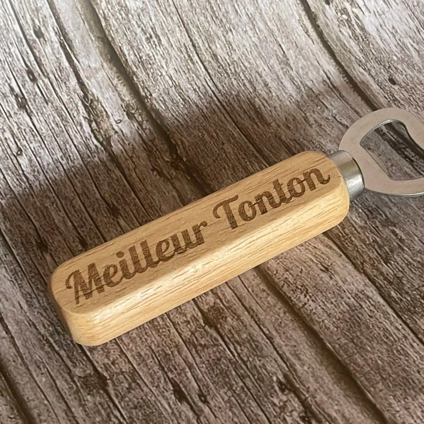 Gros plan sur la qualité de la gravure profonde "Meilleur Tonton" sur le manche en bois.